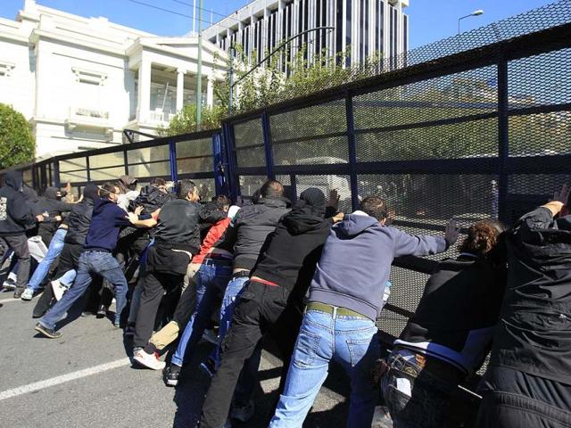 Demonstrators push a metallic police barrier outside the Greek Parliament. A two-day general strike that unions vow will be the largest in years grounded flights, disrupted public transport and shut down everything from shops to schools in Greece.