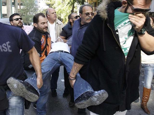 An injured anti-austerity demonstrator is carried to safety during clashes with riot police in Athens' Syntagma (Constitution) square.