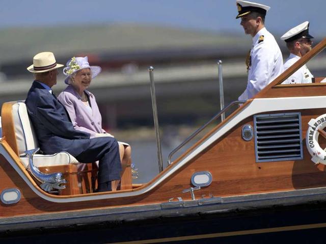 Britain's Queen Elizabeth II (2nd L) and Prince Philip (L) cruise on a navy barge on Lake Burley Griffin during their visit to Canberra. (AFP)
