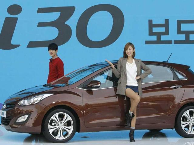 Models pose next to Hyundai Motor Co's i30 hatchback during an unveiling ceremony in Seoul, South Korea. (AP)