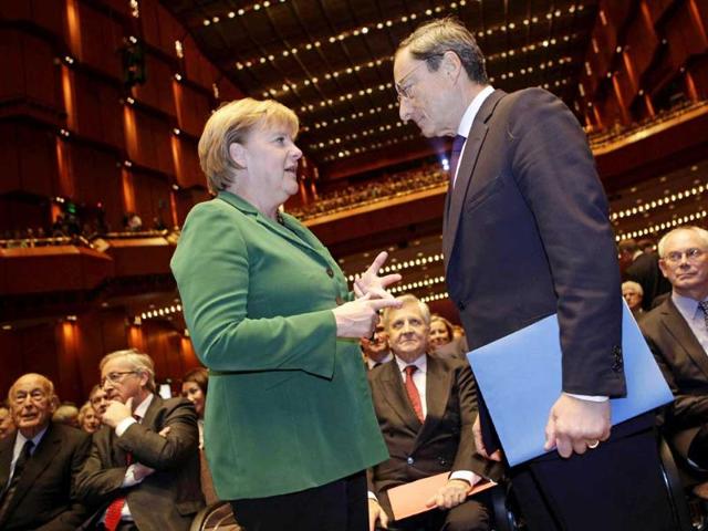 German chancellor Angela Merkel (L) talks to new European Central Bank (ECB) president Mario Draghi, prior to a farewell ceremony for outgoing ECB president Jean-Claude Trichet (C) at the old opera house in Frankfurt. (AP)