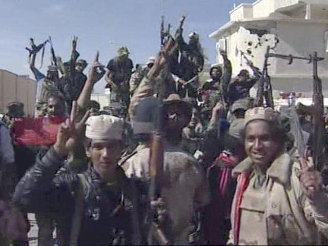 Libyan fighters celebrate in the streets of Sirte, Libya in this image taken from TV. (AP)