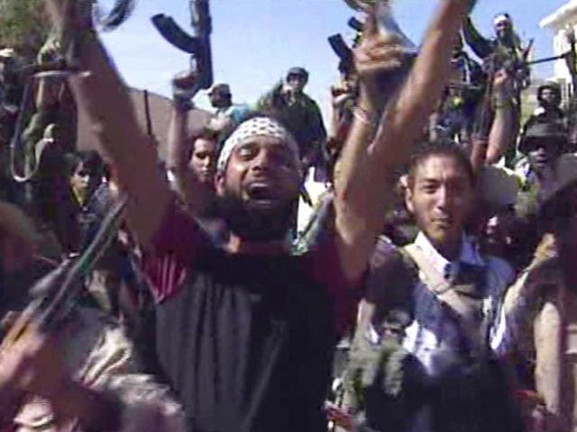 Libyan fighters celebrate in the streets of Sirte, Libya in this image taken from TV. (AP)
