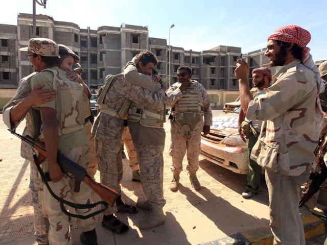 Anti-Gaddafi fighters hug as they celebrate the fall of Sirte. (Reuters/Esam Al-Fetori)