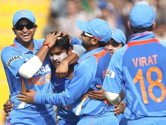 Vinay Kumar (2nd L) is congratulated by his teammates after taking the wicket of England's captain Alastair Cook during India's third one-day international cricket match in Mohali.