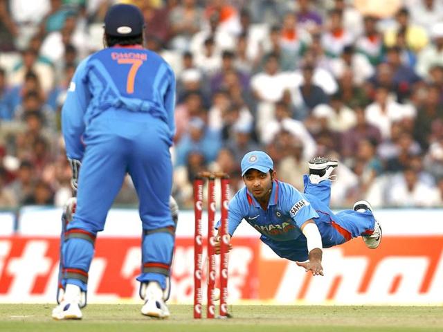 Ajinkya Rahane (R) dives as he throws the ball in an unsuccessful attempt to run out England's Ravi Bopara (unseen) during India's third one-day international cricket match in Mohali.