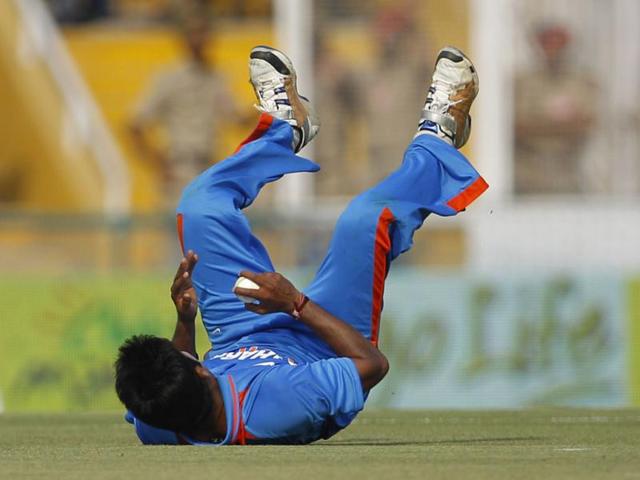 Vinay Kumar falls on the ground in an attempt to field the ball during India's third one-day international cricket match against England in Mohali.