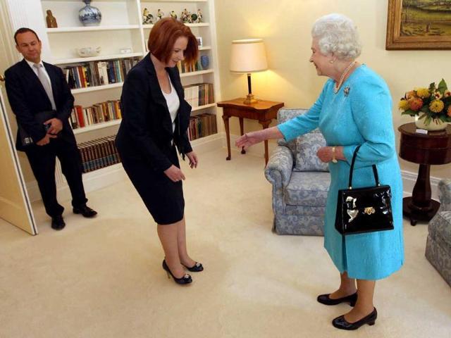 Britain's Queen Elizabeth II greets Australian Prime Minister Julia Gillard (C) during their meeting at Government House in Canberra as part of her 10-day Australian tour. (AFP)