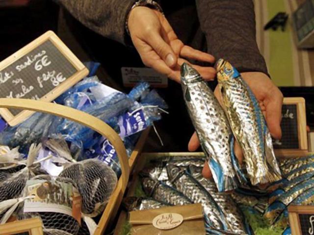 A chocolate maker holds sardine-shaped chocolates a stand of the 17th Salon du Chocolat (chocolate fair) in Paris. (AFP)