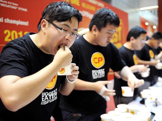 Participants wolf down shrimp wontons in eight minutes during a dumpling eating contest, known as the CP Biggest Eater Competition, at a shopping mall in Singapore.