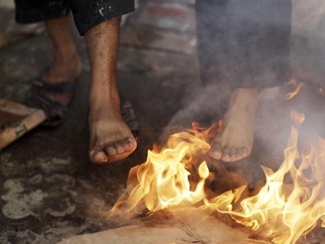 Afghan workers warm their feet on a roadside in Kabul, Afghanistan.