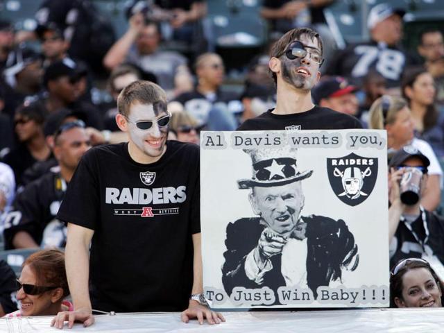 Oakland Raiders fans cheer on their team with a reference to Al Davis in the fourth quarter of a game against the Kansas City Chiefs at O.co Coliseum in Oakland, California.