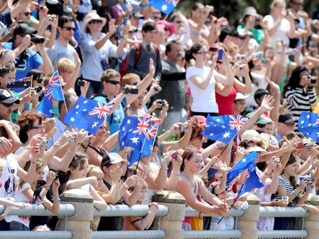 Schoolchildren and residents cheer Britain's Queen Elizabeth II as she passes on the catamaran 'Pure Adrenalin' during the royal boat tour along the Brisbane River.