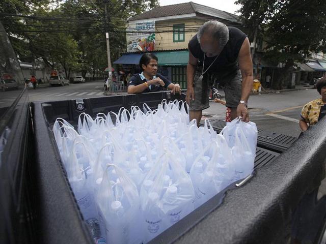 A family carries bags of drinking water to their truck in Bangkok. Fears of flooding across the Thai capital grew after prime minister Yingluck Shinawatra warned parts of Bangkok could face inundation for up to a month, with authorities calling a special five-day holiday to allow people to leave.