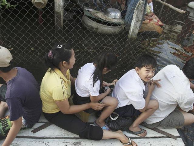 People sit on a raft in the floodwaters in Phnom Penh. Floods have killed at least 247 people in Cambodia, which is the worst in a decade, while more than 230,000 hectares of rice paddies have been damaged, according to the Cambodian National Disaster Management Committee (CNDMC).
