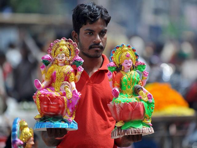 A vendor sells statues of the Hindu deity Lakshmi, the goddess of prosperity, wealth, and purity, at a market on the eve of Diwali, the festival of lights, in Hyderabad.