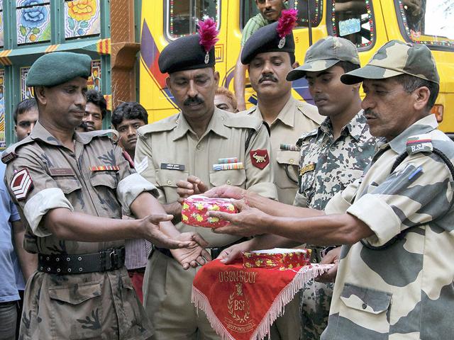 Bangladesh Rifles personnel (L) and Indian Border Security Force personnel greet each other with sweets on the occasion of Diwali festival, at the Akhaura check-post on the outskirts of Agartala.
