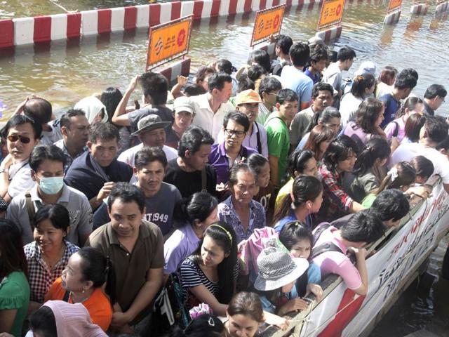 Local residents riding on a vehicle evacuate from a flooded area to a safer place in Bangkok, Thailand. (AP)