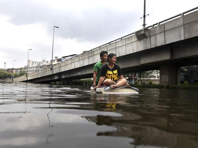 Thai residents ride a makeshift boat as they leave flooded area in Bangkok, Thailand. (AP)