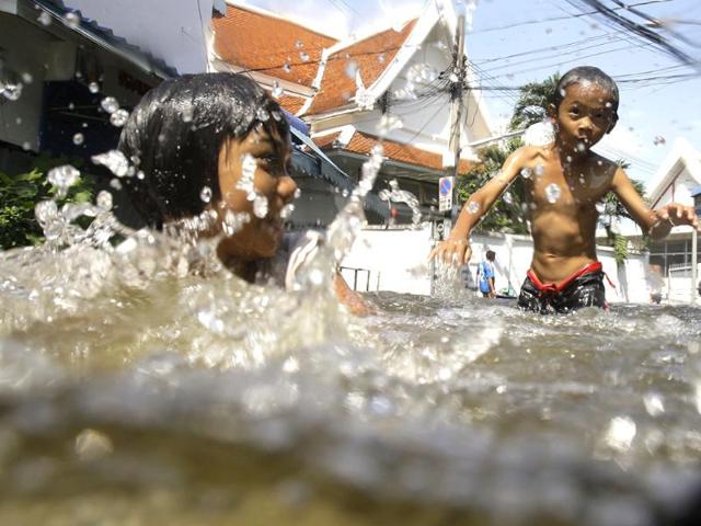 Thai children play along a flooded area in Bangkok. (AP)