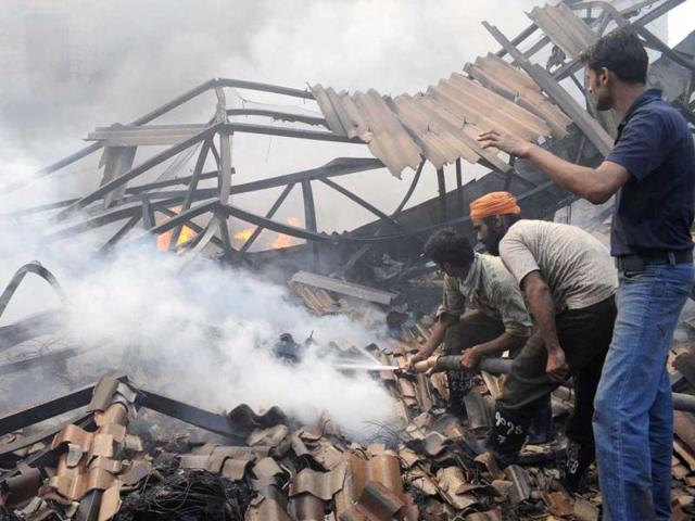 Rescue workers extinguish a fire which engulfed the Kochar Sung-Up Acrylic factory outside Amritsar. The fire was allegedly caused by a an electrical short circuit, officials said.