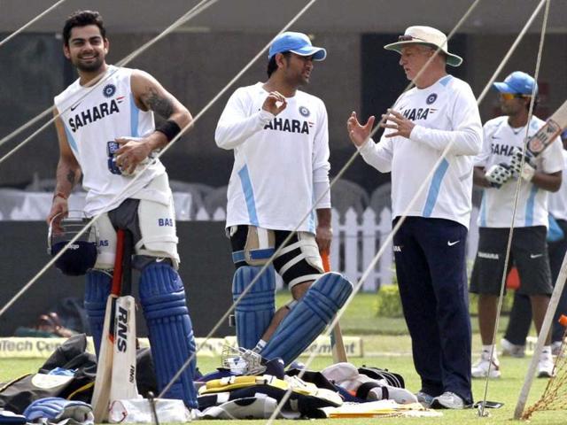Mahendra Singh Dhoni listens to team coach Duncan Fletcher, as teammate Virat Kohli smiles, during a practice session ahead of their Twenty20 international cricket match against England in Kolkata.