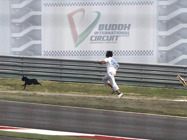 Course-marshals-chase-away-a-stray-dog-on-the-track-before-the-first-practice-session-starts-ahead-of-the-Indian-Formula-One-Grand-Prix-at-the-Buddh-International-Circuit-in-Greater-Noida-Reuters