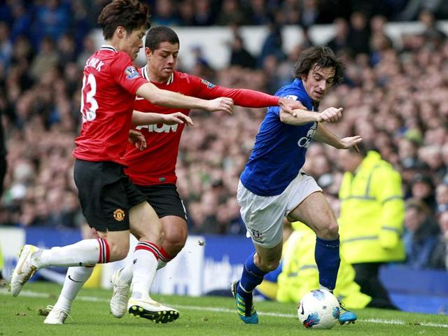 Manchester United's Ji-Sung Park (L) and Javier Hernandez vie for the ball against Everton's Leighton Baines during their English Premier League soccer match at Goodison Park, Liverpool. (AP)