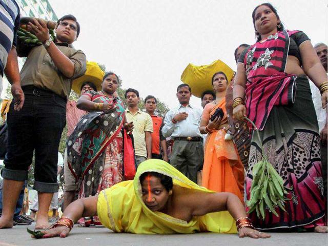 A woman devotee lying prostrate as she proceeds to perform Chhath puja in Kolkata.