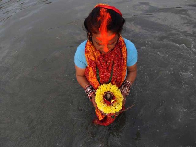 A Nepalese Hindu woman worships the sun as she stands in the Bagmati River during the Chhath festival, which honours the Sun God, in Kathmandu. People pay their respects to both the rising and setting sun during the Chhath festival when people express their thanks and seek blessings from the forces of nature.
