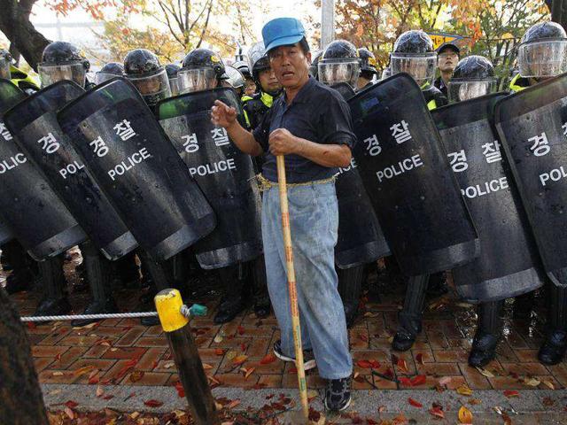 A protester reacts as he is blocked by the riot police during a rally against the South Korea-US free trade agreement (FTA) talks in front of the National Assembly in Seoul. Thousands of protesters including farmers, unionised workers and university students took part in the rally.