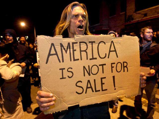 Protesters from Occupy DC march near the Washington Convention Center during a demonstration against the billionaire conservative donor Koch brothers and Americans for Prosperity in Washington, DC.