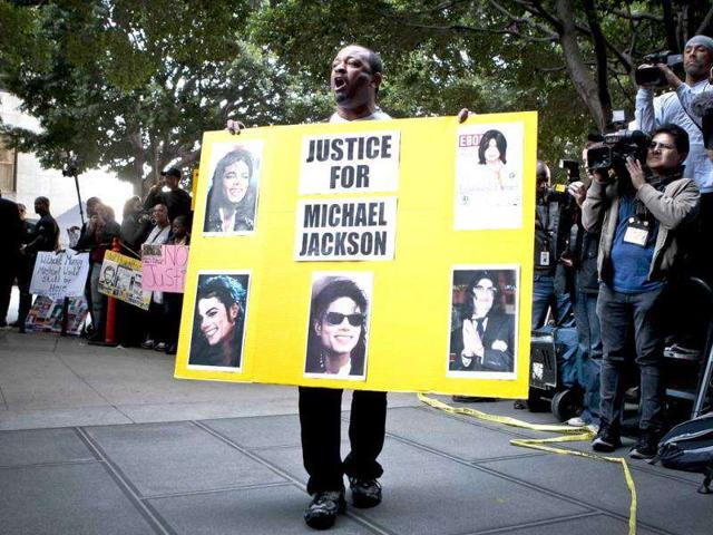 A Michael Jackson fan celebrates in front of the media after it was announced that Dr Conrad Murray, Michael Jackson's physician when the pop star died in 2009, was convicted of involuntary manslaughter at the Criminal Justice Center, in Los Angeles.