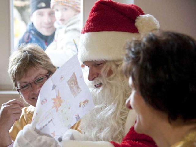A man dressed as Santa Claus sits with his 'helpers' who are busy answering children's letters in the Santa Claus post office in the Eastern German town of Himmelpfort (Heaven's Gate). Children can send their Christmas wish lists to Himmelpfort from around the world and receive a reply from Santa. AFP Photo / John Macdougall