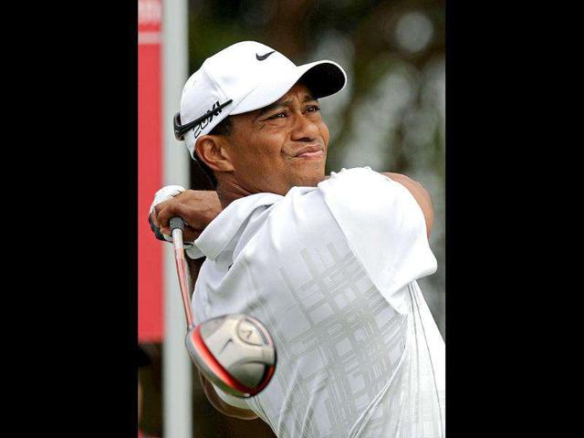 Tiger Woods of the US watches the ball after playing a tee shot in front of an advertising billboard during round two of the Australian Open golf tournament in Sydney. (Photo: AFP)