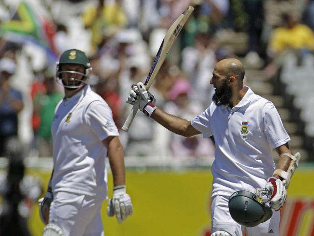South Africa's Hashim Amla, right, holds up his bat after scoring a century during a cricket Test match against Australia in Cape Town, South Africa.