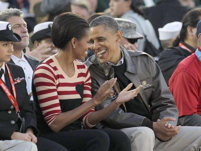 Barack Obama and first lady Michelle Obama speak to one another during the NCAA men's college basketball Carrier Classic. Getty Images/AFP