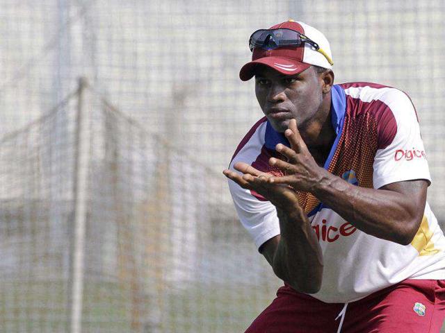 West Indies' cricketer Marlon Samuels cups his hands to catch a ball during a practice session prior to the second test cricket match against India in Kolkata. India leads 1-0 in the series. AP Photo/Bikas Das