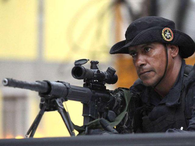 A Brazilian sniper takes position at Rocinha slum during the "Shock of Peace" operation to install Peacekeeping Unit (UPP) in Rio de Janeiro. The introduction of the peacekeeping program in the region is part of the effort crack down on crime and ensure the security as the city prepares to host 2014 World Cup soccer matches and the 2016 Olympic Games.