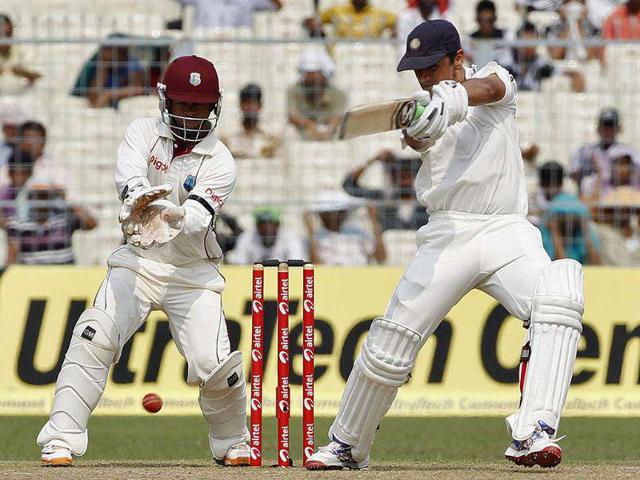 Rahul Dravid (R) plays a shot as West Indies' wicketkeeper Carlton Baugh watches on the first day of their second Test cricket match in Kolkata.