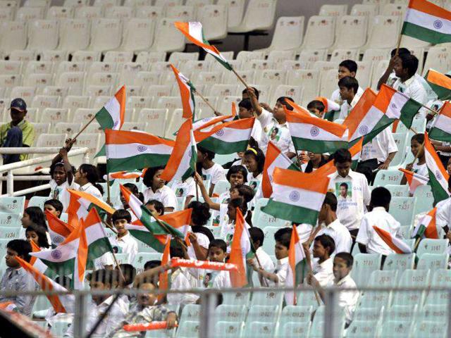 School children wave Indian flags as they support the home team during the second Test cricket match against West Indies in Kolkata.