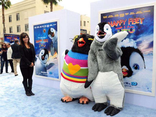 Movie characters Lovelace (L), voiced by Robin Williams, and Mumble (R), voiced by Elijah Wood strike a pose.