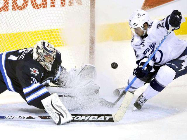 Winnipeg Jets goaltender Ondrej Pavelec makes a save on Tampa Bay Lightning's Ryan Shannon (R) during the second period of their NHL game in Winnipeg. (Reuters Photo/Fred Greenslade)