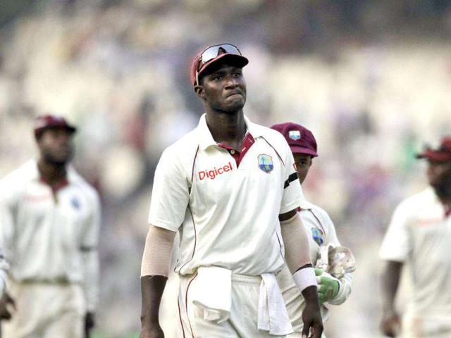 West Indies captain Darren Sammy, center, leaves the ground with teammates at the end of their mach during first day of the second cricket Test match against India in Kolkata.