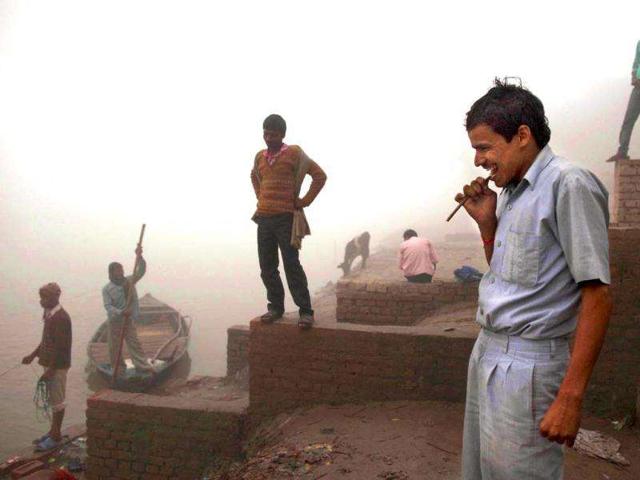 A man brushes his teeth with a neem stick on the banks of the Ganges River at the site of the Sonepur Fair near Patna.