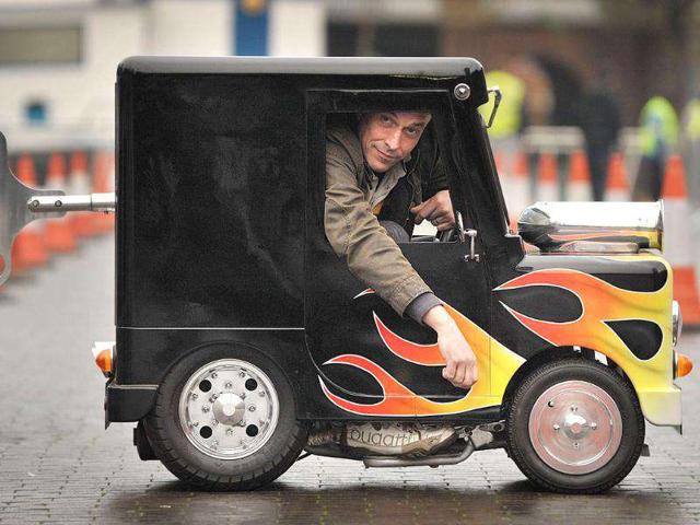 British inventor of the world's smallest legally roadworthy car Perry Watkins sits in his vehicle measuring 104.14cm high, 66.04cm wide and 132.08cm long at Guinness World Records Day.