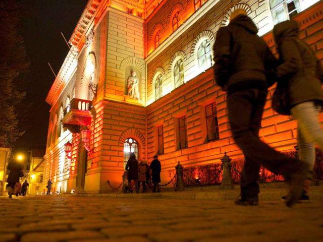 People walk by the light facility 'Parliament of Latvia' during the Staro Riga? light festival in Riga on November 17, 2011, to mark the Latvia's Independence Day. AFP Photo / Ilmars Znotins