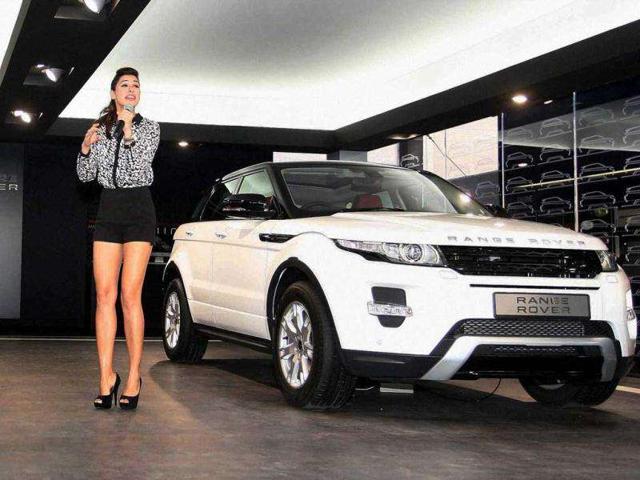 Nargis' black and white outfit complements the white SUV. Nargis' black and white outfit complements the white SUV.