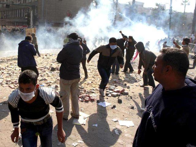 Protesters run away from tear gas fired by riot police during clashes between protesters and police near Tahrir Square in Cairo. Photo: Reuters/Asmaa Waguih