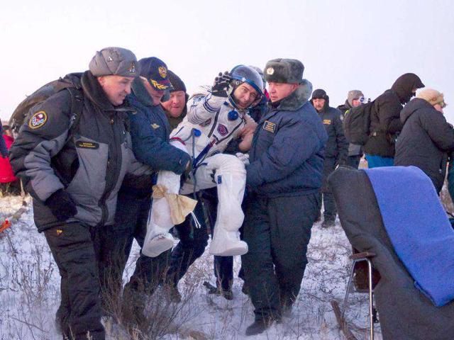 Russia's space agency ground personnel carry Russian cosmonaut Sergei Volkov shortly after his landing in Soyuz TMA-02 capsule near the town of Arkalyk in northern Kazakhstan. AFP PHOTO / Shamil Zhumatov